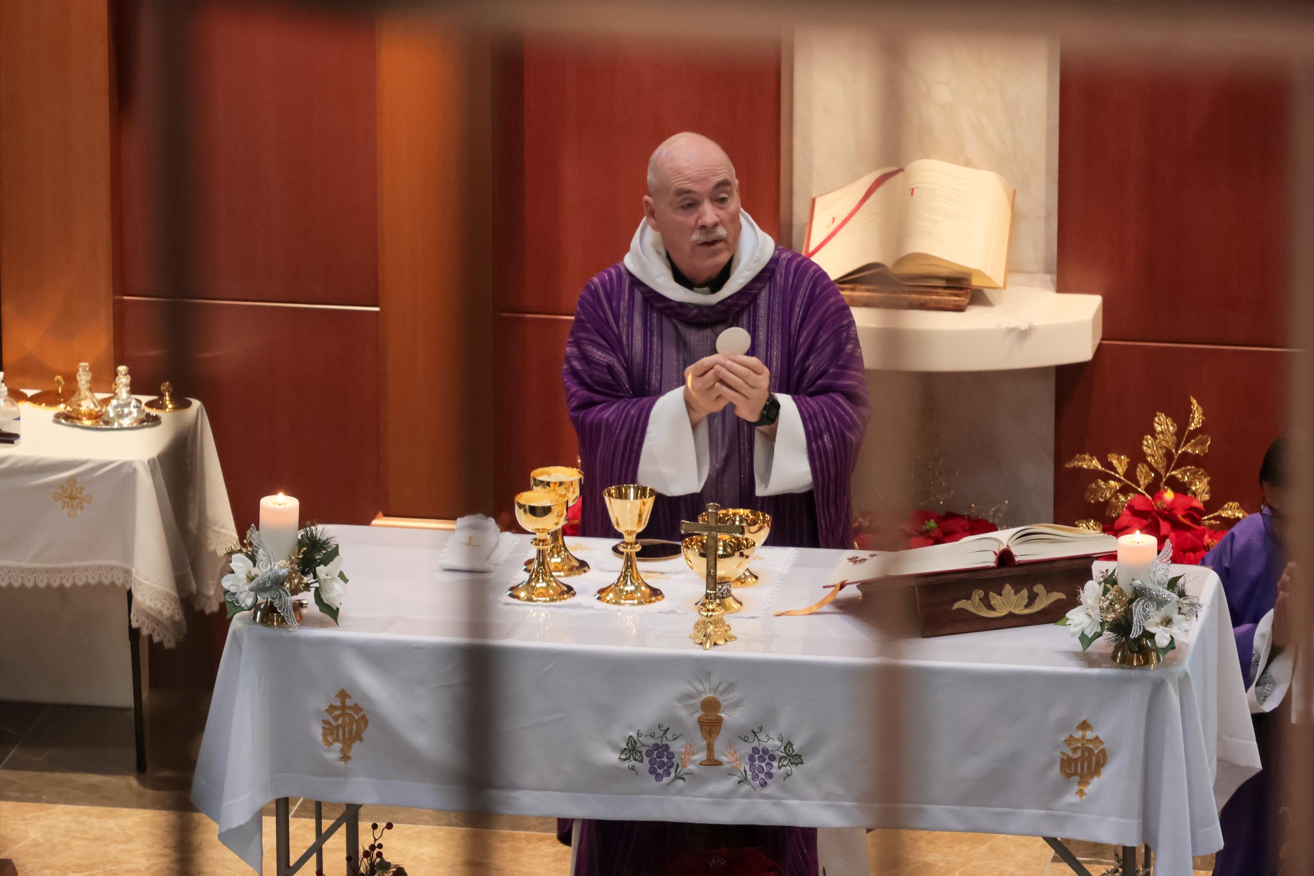 Families remember loved ones during Advent Mass at Holy Cross Cemetery ...